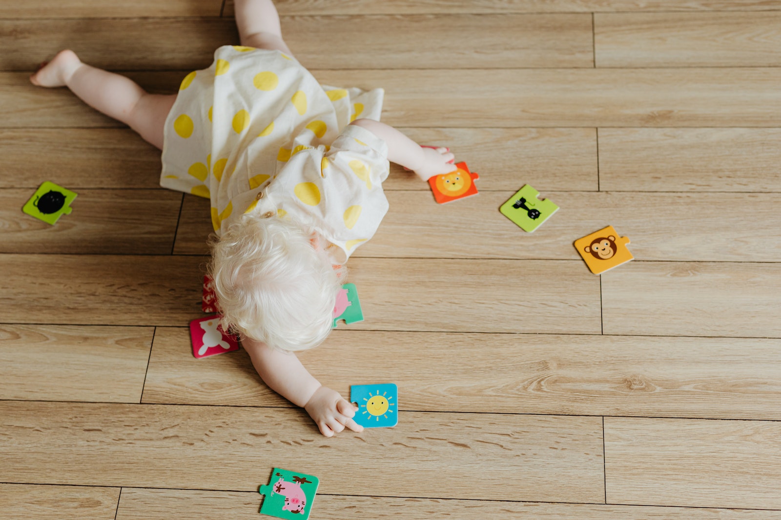 A Toddler Playing with Puzzle Pieces on the Floor