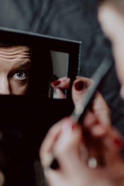 woman holding black framed mirror