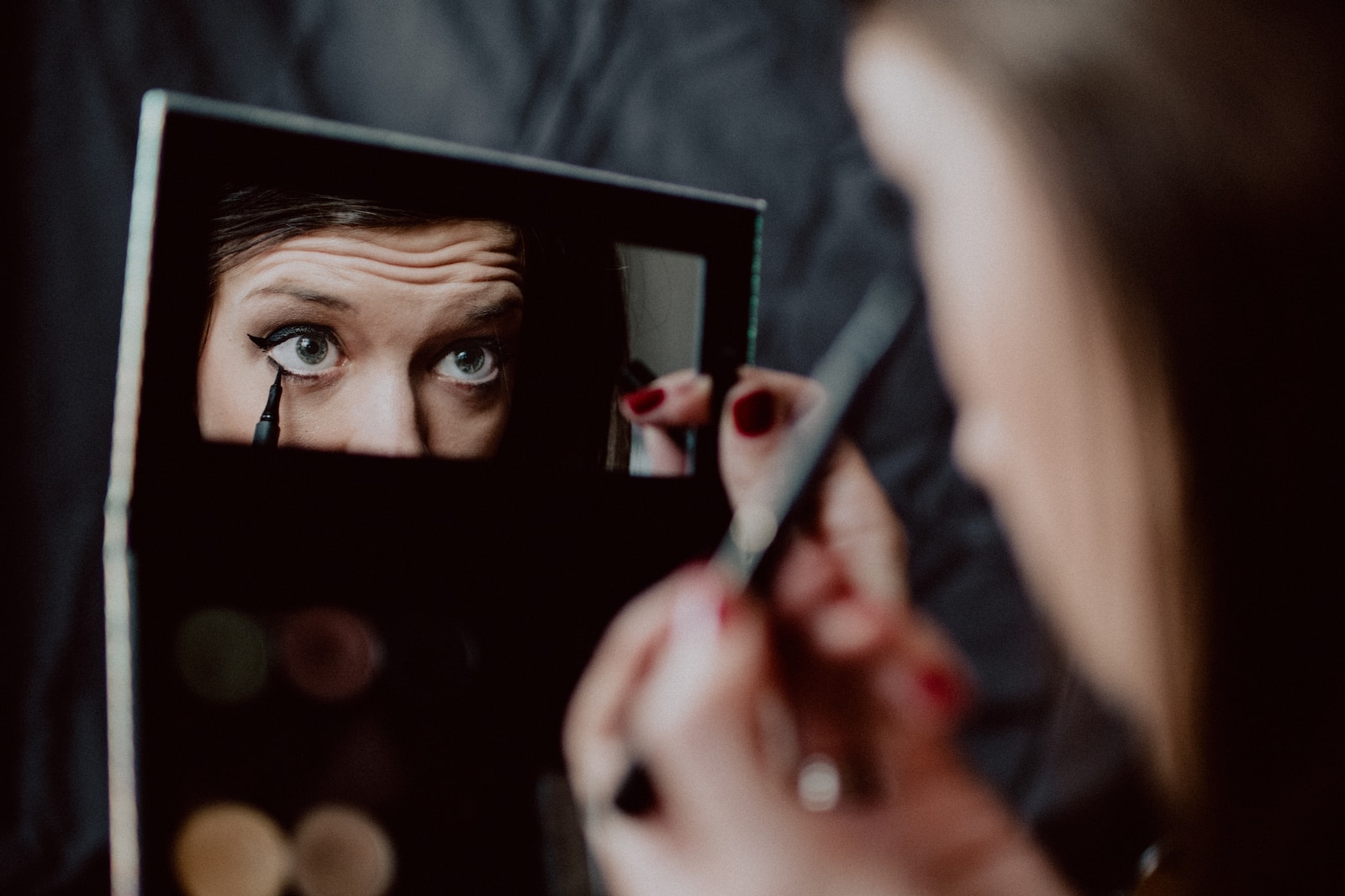 woman holding black framed mirror