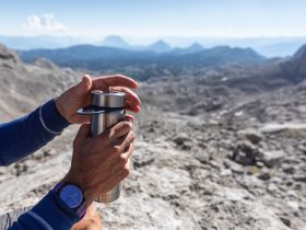 person holding stainless steel cup