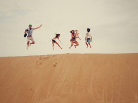 people jumping on sand