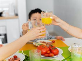 Two Women and Boy Toasting with Glasses of Juice During Dinner