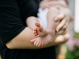 person carrying baby on arms