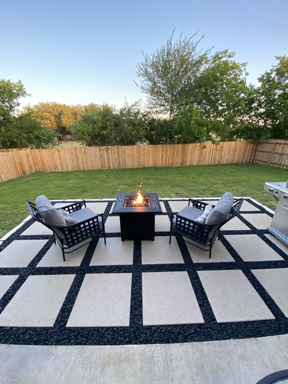Black Gravel Patio With Large White Square Paver And Fire Pit