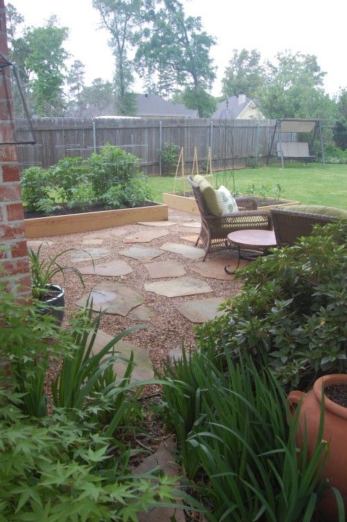 Brown Gravel Patio With Flat Stones And Edged With Raised Garden Beds