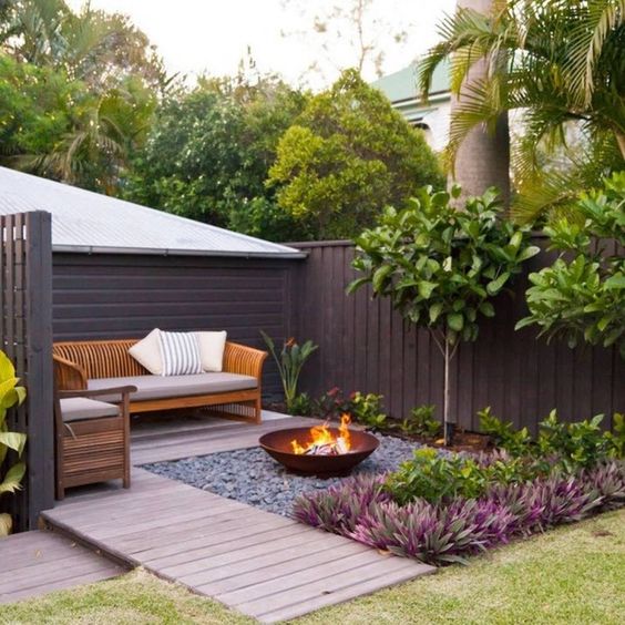 Corner Patio With Wood Plank, Center Gravel With Fire Pit Edged With Plants