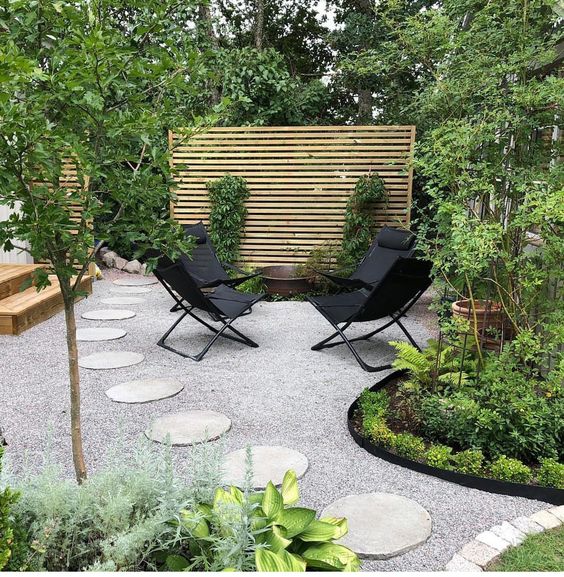 Gravel Patio With Round Paver Path And Fire Pit Bext To A Privacy Screen