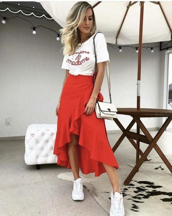 T-Shirt Tucked In A red Assymetrical Red Skirt With Sneakers