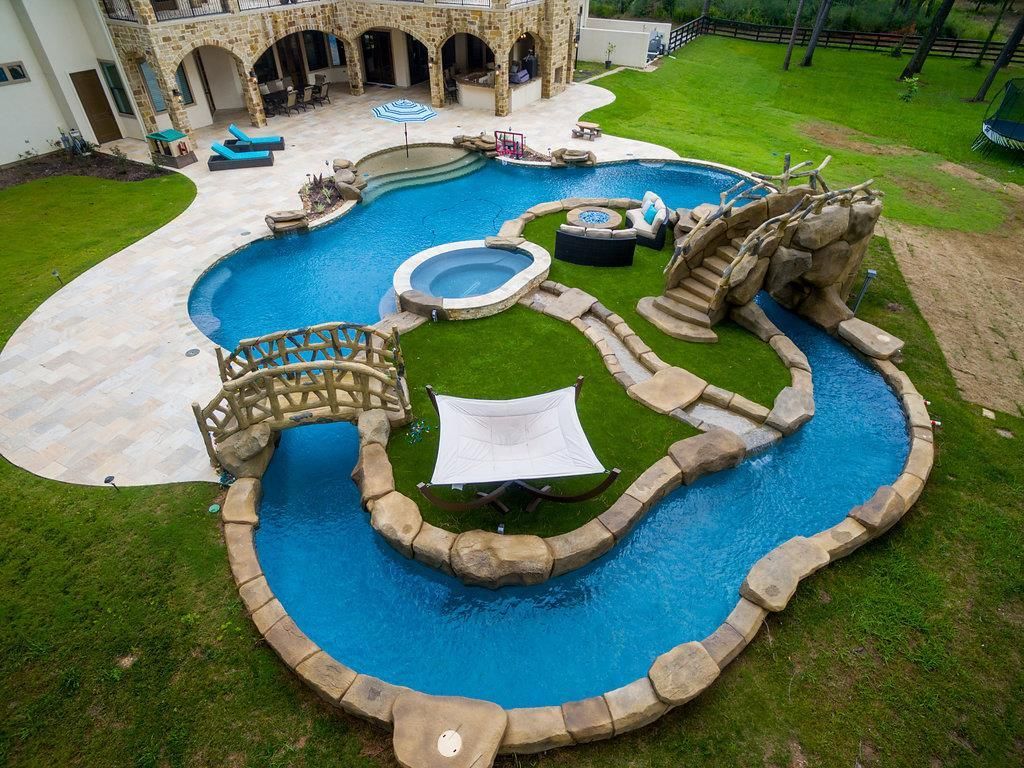 Lazy-River-Pool-With-Two-Bridges-Hot-Tub-And-Green-Grass-Island.