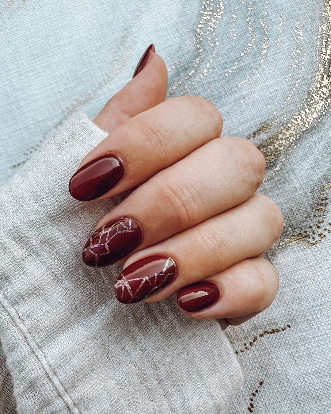 Oval Burgundy Nails With Golden Geometric Lines