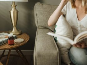 woman sitting on sofa holding book